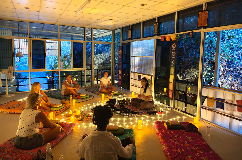people sitting on their mat listening to information about sound bath, sound healing, from teacher at samadee yoga krabi